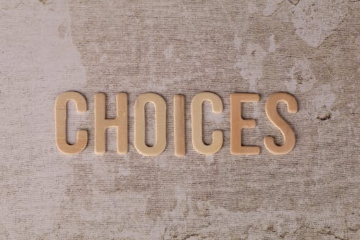 Wooden letters spelling 'choices' on a textured surface, symbolizing decision-making.